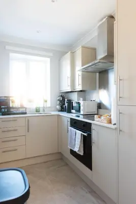 a kitchen with white cabinets and a stove top oven at 4 Bedroom Home - 2 Mins to Town CM7 - Contractor Ready in Braintree