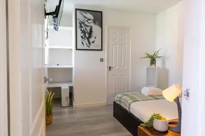 a bedroom with a bed and a white door at Luxury Five-Bedroom Home with Jacuzzi and Gym - Private One-Bedroom Garden Suite Available Separately in Basildon