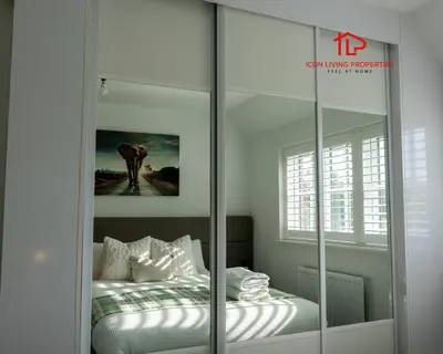 a bedroom with a bed and a large glass closet at Luxury Five-Bedroom Home with Jacuzzi and Gym - Private One-Bedroom Garden Suite Available Separately in Basildon