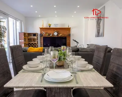 a dining room with a table with plates and glasses at Luxury Five-Bedroom Home with Jacuzzi and Gym - Private One-Bedroom Garden Suite Available Separately in Basildon