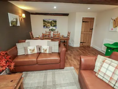 a living room with a couch and a table at Duchess Cottage in Woodbridge