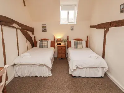 a bedroom with two beds and a dresser at Duke Cottage in Woodbridge