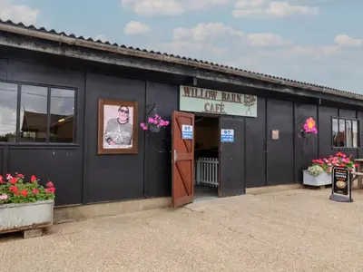 a black building with a sign that reads midnight rifle cafe at Duke Cottage in Woodbridge