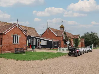 a group of buildings with a tractor parked in front at Duke Cottage in Woodbridge