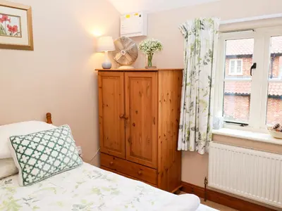 a bedroom with a bed and a dresser and a window at Hayloft in Ipswich