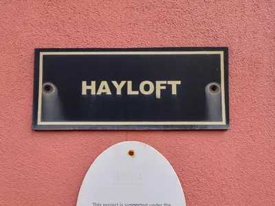 a sign on a red wall with the word yawnoit at Hayloft in Ipswich
