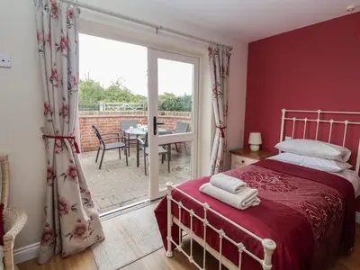 a bedroom with a bed and a sliding glass door at Fisherman's Rest in Ipswich