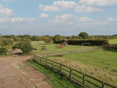 a field with a fence and a soccer goal at Fisherman's Rest in Ipswich