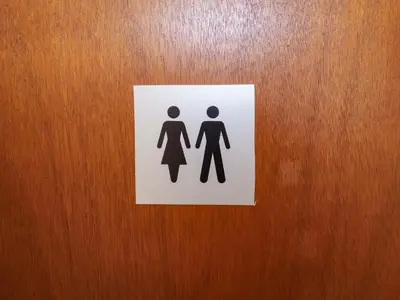 a sign on a door with a man and woman at Coachman's Cottage in Ipswich