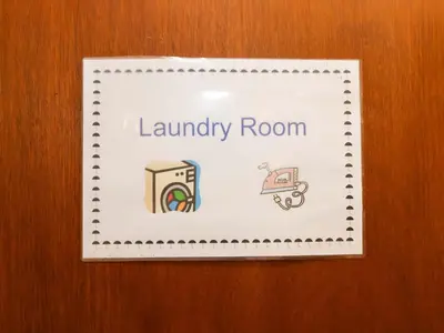 a sign for a laundry room on a wooden door at Coachman's Cottage in Ipswich