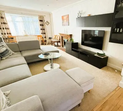 a living room with a couch and a tv at Elegant 5BDR Executive Home Chigwell in Chigwell