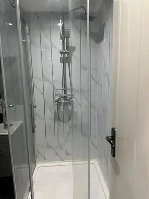 a shower with a glass door in a bathroom at A Cosy and Spacious Studio Flat in Navestock