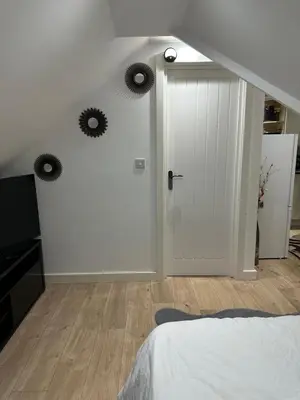 a bedroom with a white door and two mirrors on the wall at A Cosy and Spacious Studio Flat in Navestock