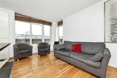 a living room with a couch and two chairs at The Luxurious Penthouse in Cambridge