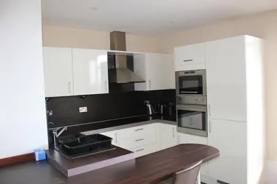 a kitchen with white cabinets and a sink at The Luxurious Penthouse in Cambridge