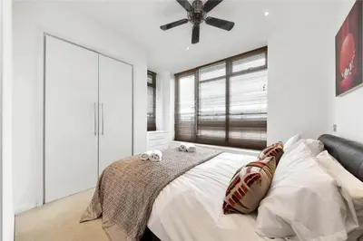 a bedroom with a bed with a ceiling fan at The Luxurious Penthouse in Cambridge