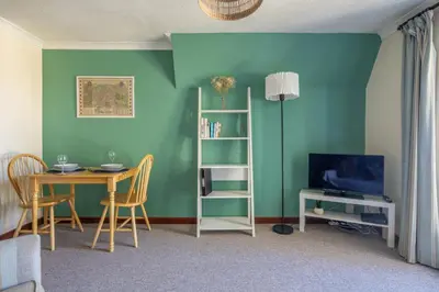 a living room with a table and a television at 1Bed Central Apt With Parking in Chesterton