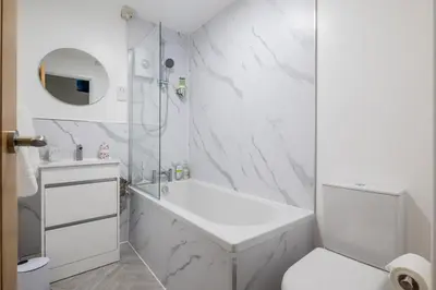 a white bathroom with a tub and a toilet at 1Bed Central Apt With Parking in Chesterton