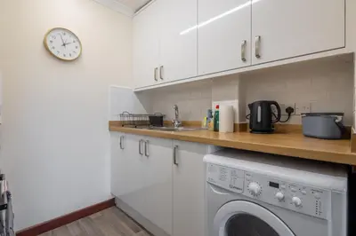 a kitchen with a dishwasher and a clock on the wall at 1Bed Central Apt With Parking in Chesterton