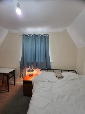 a bedroom with a bed and a blue curtain at Colchester Comfortable room Oo in Hythe