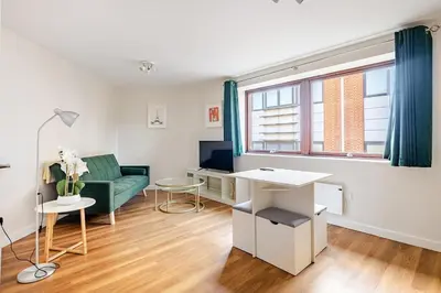 a living room with a green couch and a table at Chic escape in Cambridge