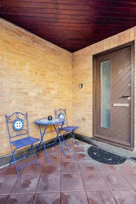 a patio with two chairs and a table and a door at Chic escape in Cambridge
