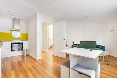 a kitchen and living room with a green couch at Chic escape in Cambridge
