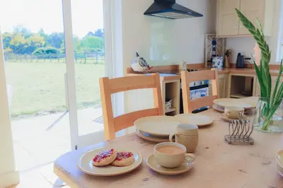 a table with plates of donuts on top of it at Lower Marsh Cottage in Brightlingsea