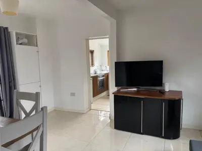 a living room with a flat screen tv on a table at 2 Willow Cottage in Takeley