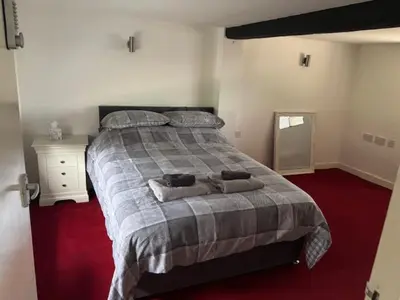 a bedroom with a large bed with two pillows on it at 2 Willow Cottage in Takeley