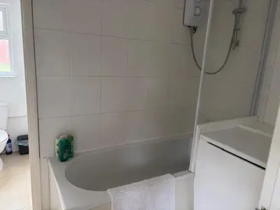 a white bathroom with a tub and a sink at 2 Willow Cottage in Takeley