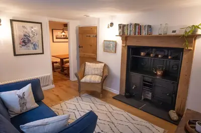 a living room with a couch and a fireplace at The Old Scullery in Bungay