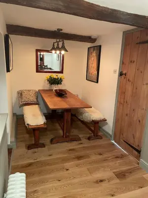 a dining room with a wooden table and two chairs at The Old Scullery in Bungay
