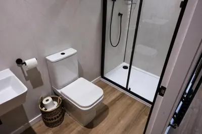 a bathroom with a toilet and a shower and a sink at The Granary Estates