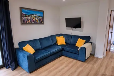 a blue couch in a living room with yellow pillows at The Granary Estates