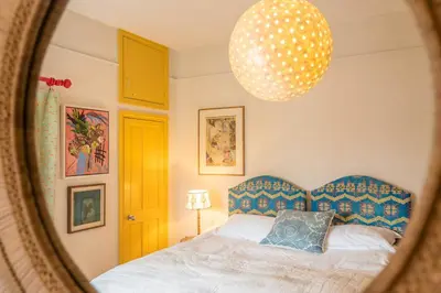 a bedroom with a bed and a mirror at 11b Market Cross Place, Aldeburgh in Aldeburgh