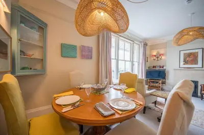 a dining room with a wooden table and chairs at 11b Market Cross Place, Aldeburgh in Aldeburgh