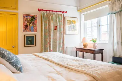 a bedroom with a bed and a window and a table at 11b Market Cross Place, Aldeburgh in Aldeburgh