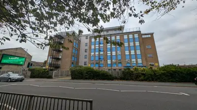 a building with blue windows on a city street at Harlech House Flats in Clacton-on-Sea
