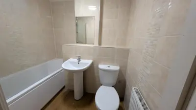 a bathroom with a toilet and a sink and a bath tub at Harlech House Flats in Clacton-on-Sea