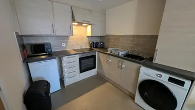 a small kitchen with a washer and a dishwasher at Harlech House Flats in Clacton-on-Sea