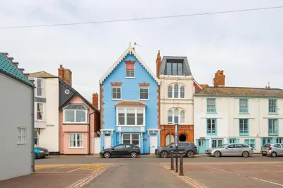 a blue building with cars parked in a parking lot at Orlando, Aldeburgh in Aldeburgh