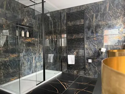 a bathroom with a glass shower with a tub at Sarah Hotel in Harwich
