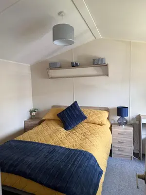 a bedroom with a bed with a blue blanket at Cosy Little Home By The Sea in West Mersea