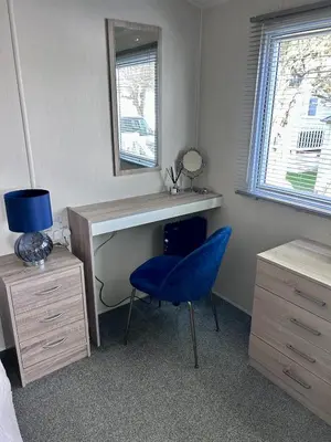 a bedroom with a desk and a blue chair at Cosy Little Home By The Sea in West Mersea