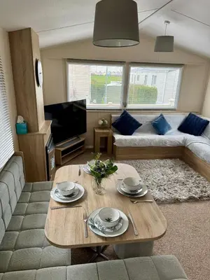 a living room with a couch and a table at Cosy Little Home By The Sea in West Mersea