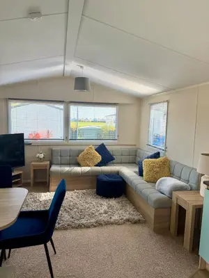 a living room with a couch and a tv at Cosy Little Home By The Sea in West Mersea