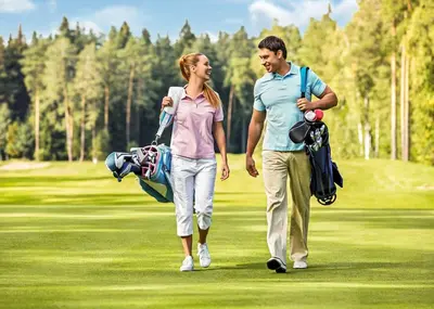 a man and a woman walking on a golf course at Warren Lodges in Little Baddow