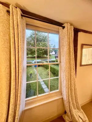 a window with curtains and a view of a yard at Manor Cottage in Cavendish