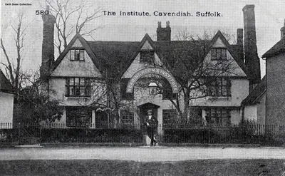 a man standing in front of a large house at Manor Cottage in Cavendish